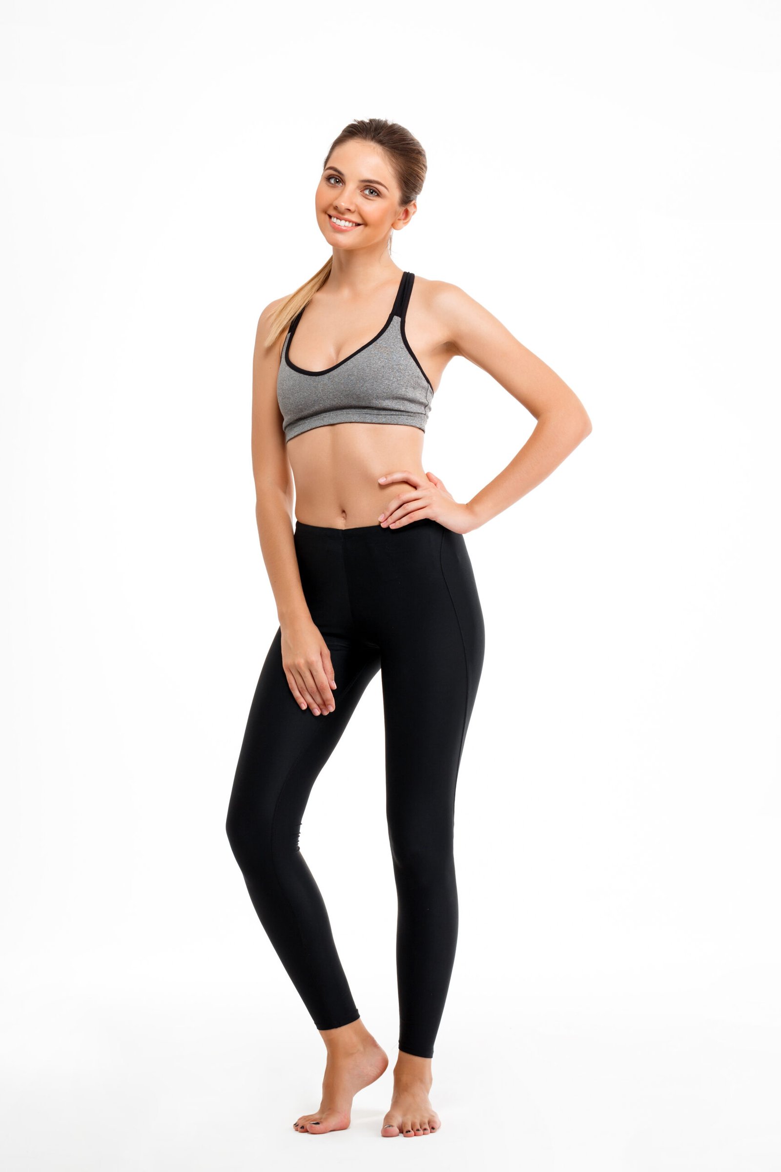 Portrait of young beautiful sportive girl over white background.